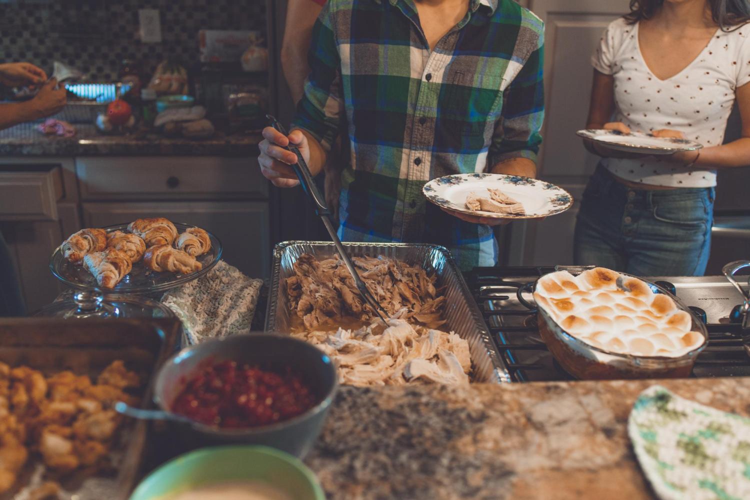 Person making a plate of food at Thanksgiving dinner