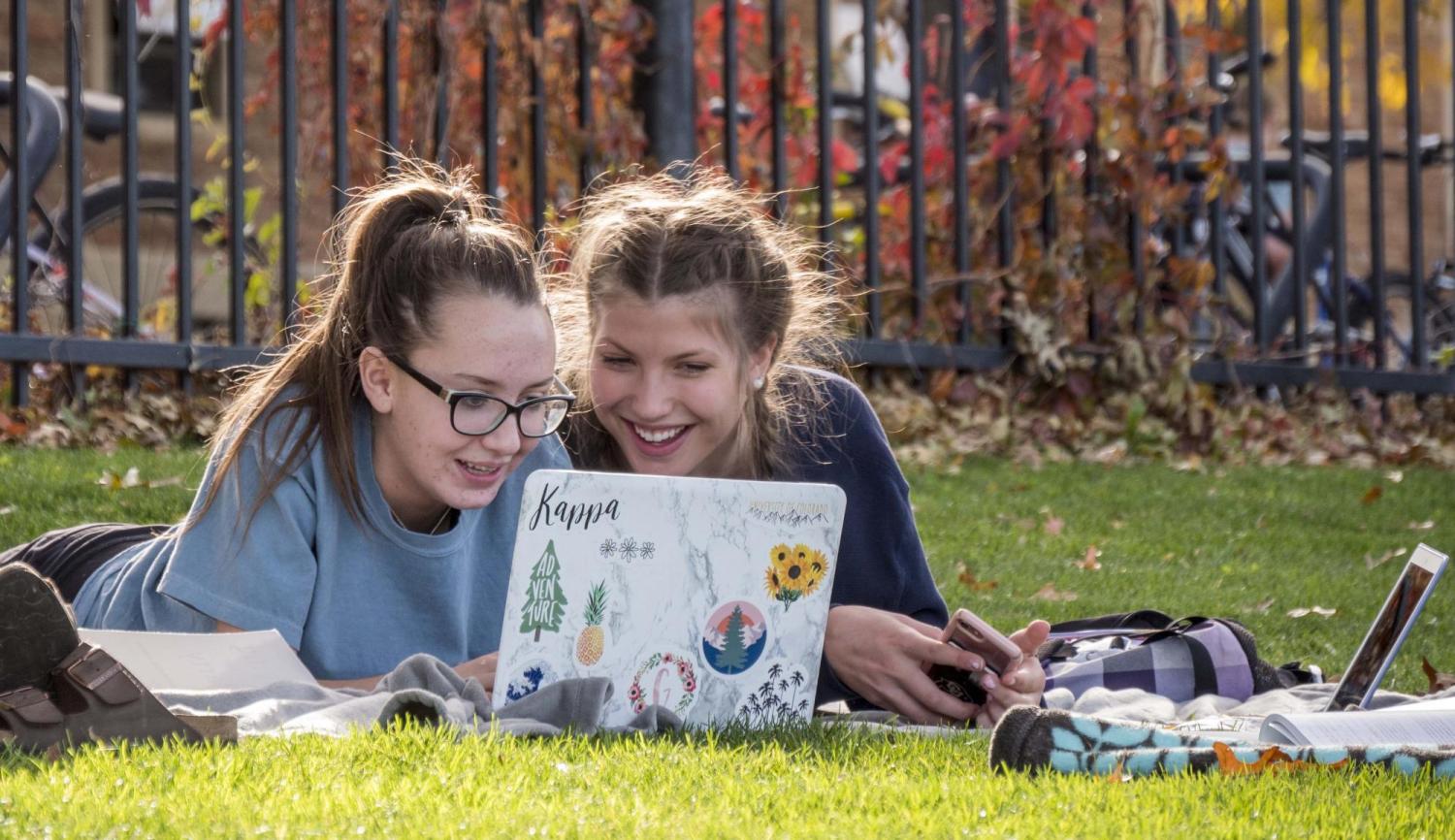 Students working on laptop outside