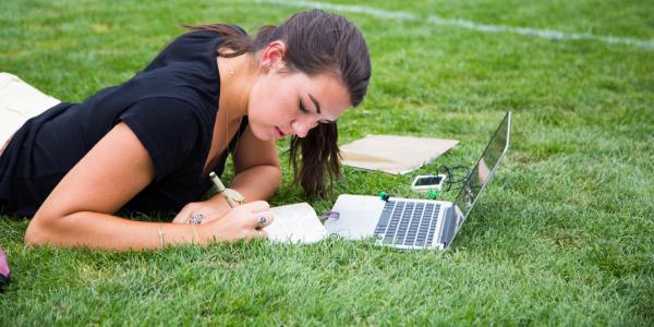 student studying in grass