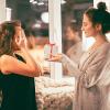 person gives a gift to a friend, who is covering her eyes