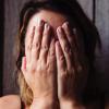 Person holds her face in her hands