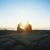 Woman sits on hill at sunset