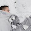 A person laying in bed next to tissures