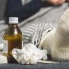 Sick person on couch with cold care supplies