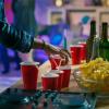 student taking a red plastic cup from a table at a party