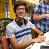 A CU student sitting at a table with their laptop