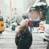 Person walking around city while snowing