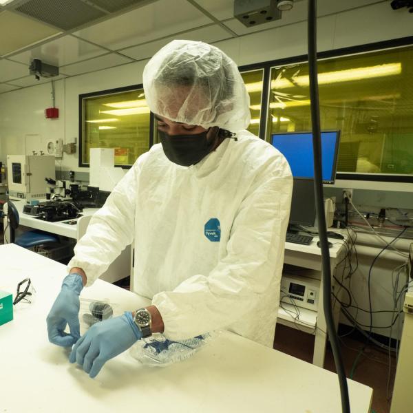 A person working with small equipment in a clean room
