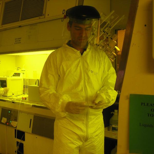 Men in lab suits are inspecting their work