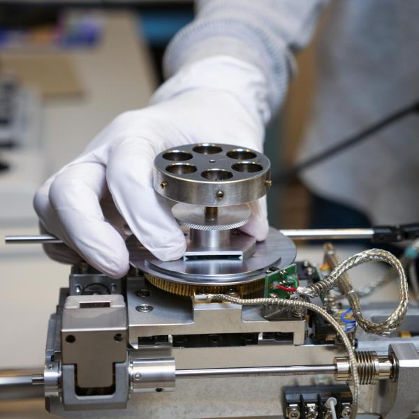 A gloved hand is interacting with the equipment.