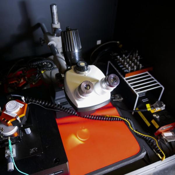A scope positioned over a red board with other equipment.