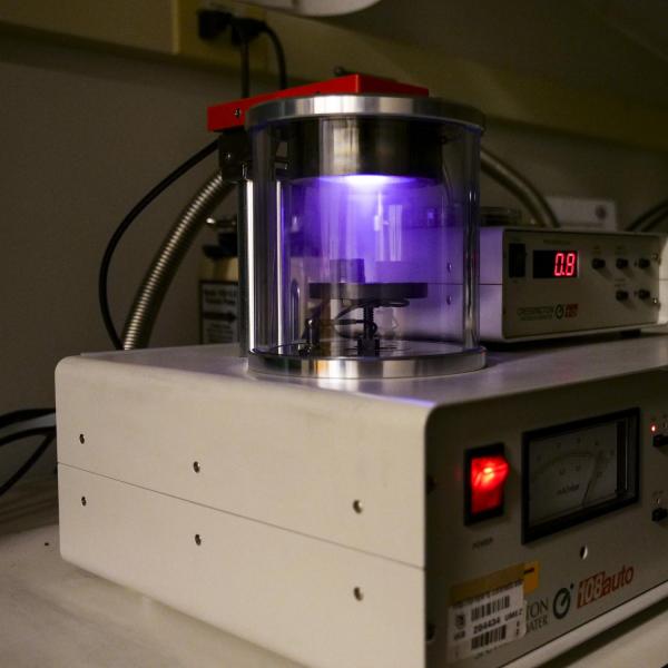 A canister with a purple light sits above monitoring equipment.