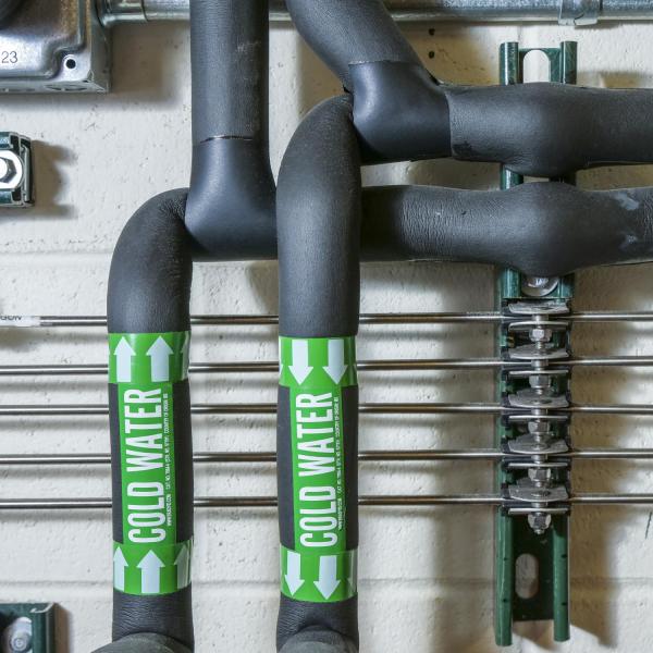 Grey pipes labelled with green text that says cold water.