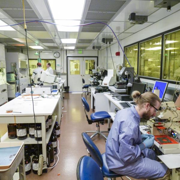 A room filled with lab equipment and a couple people working.