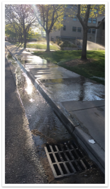A picture of excess lawn irrigation entering a storm sewer system