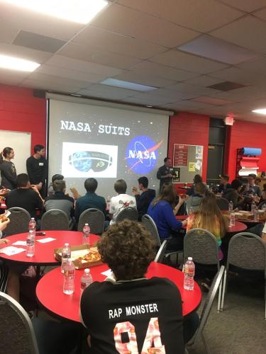  2 guys, 1 girl. The screen has the NASA logo.