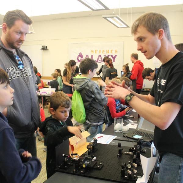 Graduate student Alex Anderson explaining twisted light tabletop demo.