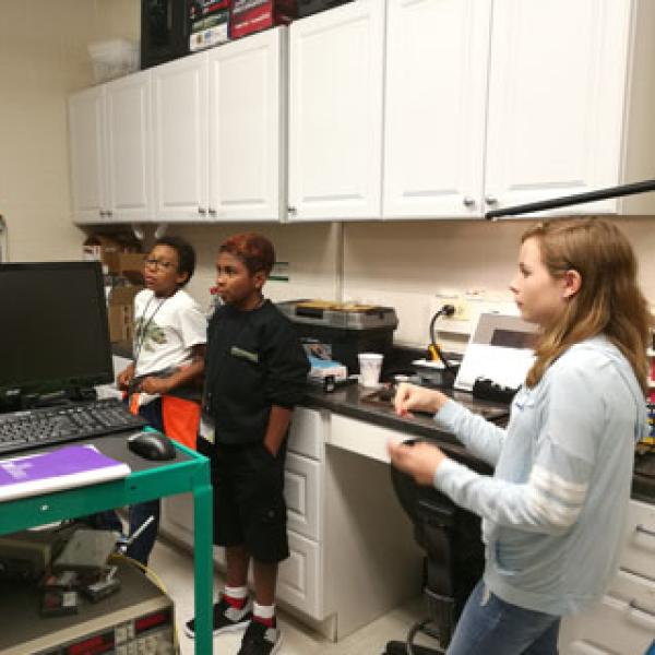 Postdoc Jiangang Zhu explaining nanophotonics to the students.