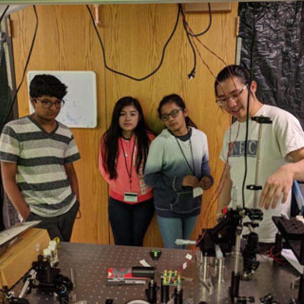 Graduate student Wei Lim explaining adaptive optics for studying the brain and neurological disease