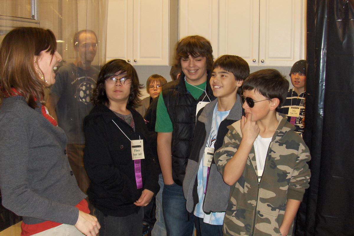 Juliet laughs with a group of students in her lab.