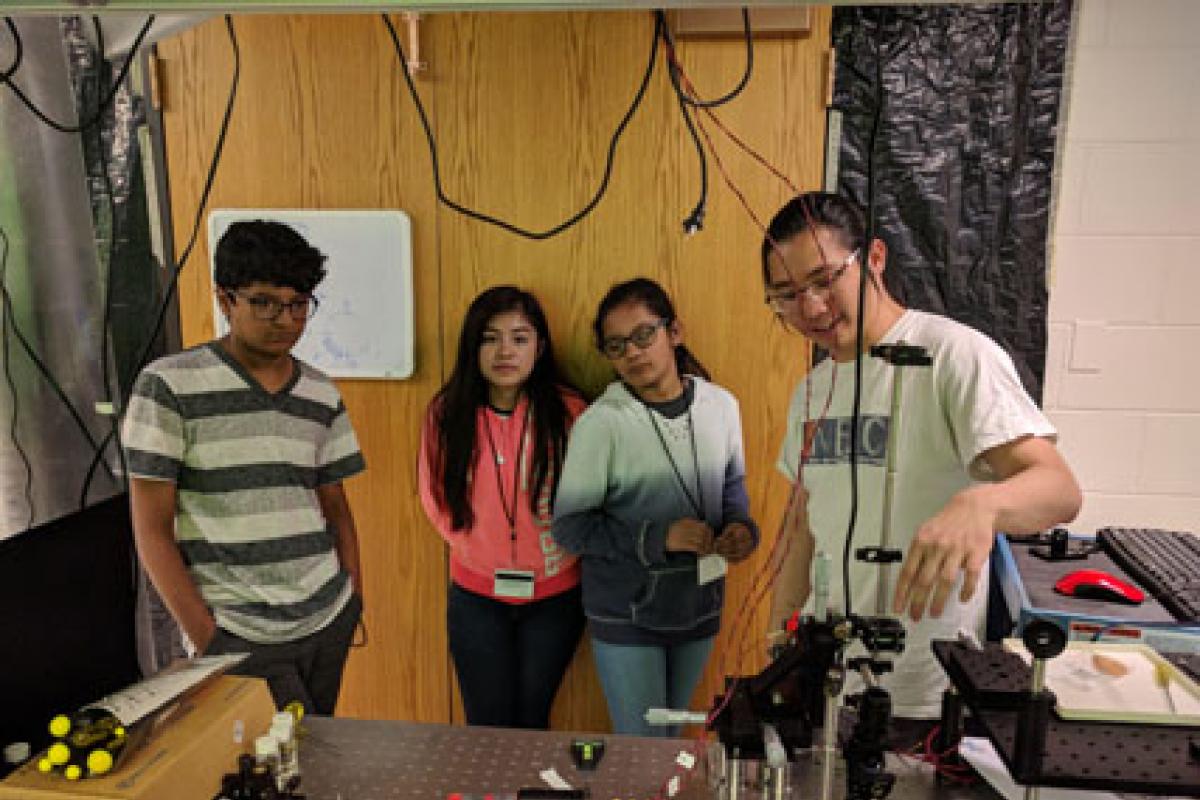 Graduate student Wei Lim explaining adaptive optics for studying the brain and neurological disease
