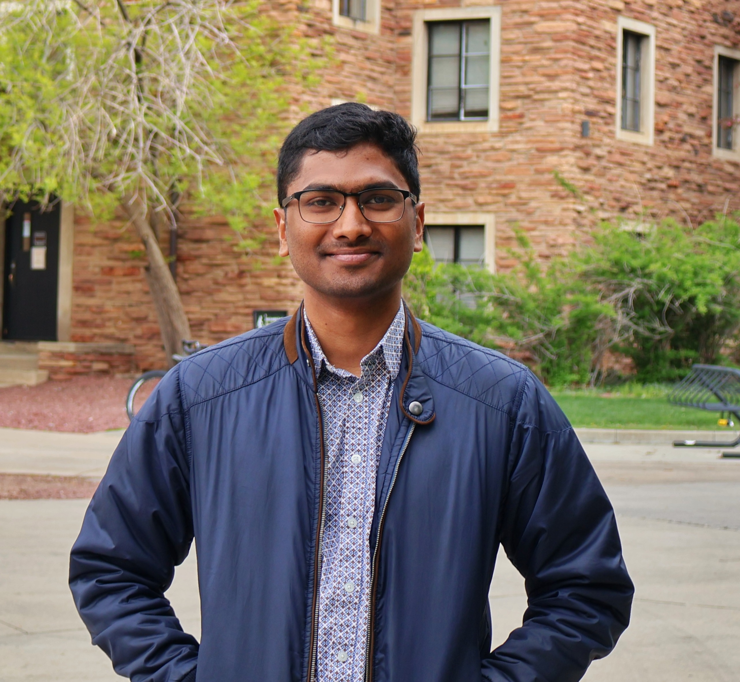 Joel Johnson standing in a blue jacket in the engineering courtyard