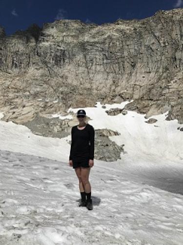 Paige Danielson standing on a snow field in the mountains