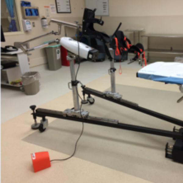 A room with testing equipment. There is a board for a person to sit or lay and sensors that connect.