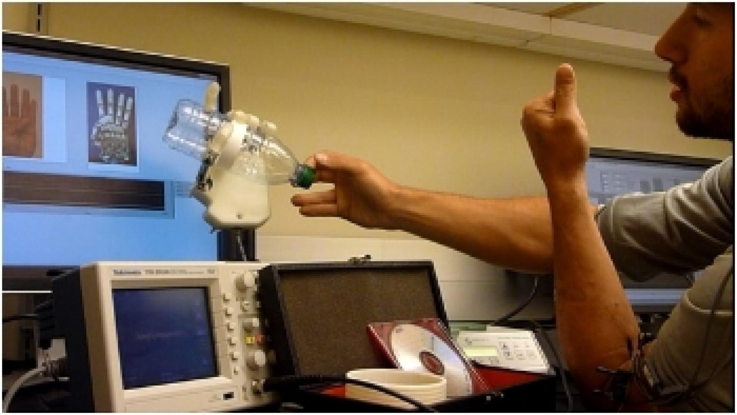 A prosthetic hand holding a bottle.