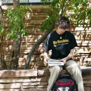 student studying with book (Photo by Glenn Asakawa/University of Colorado)