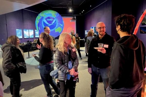 Faculty mingling at planetarium setting