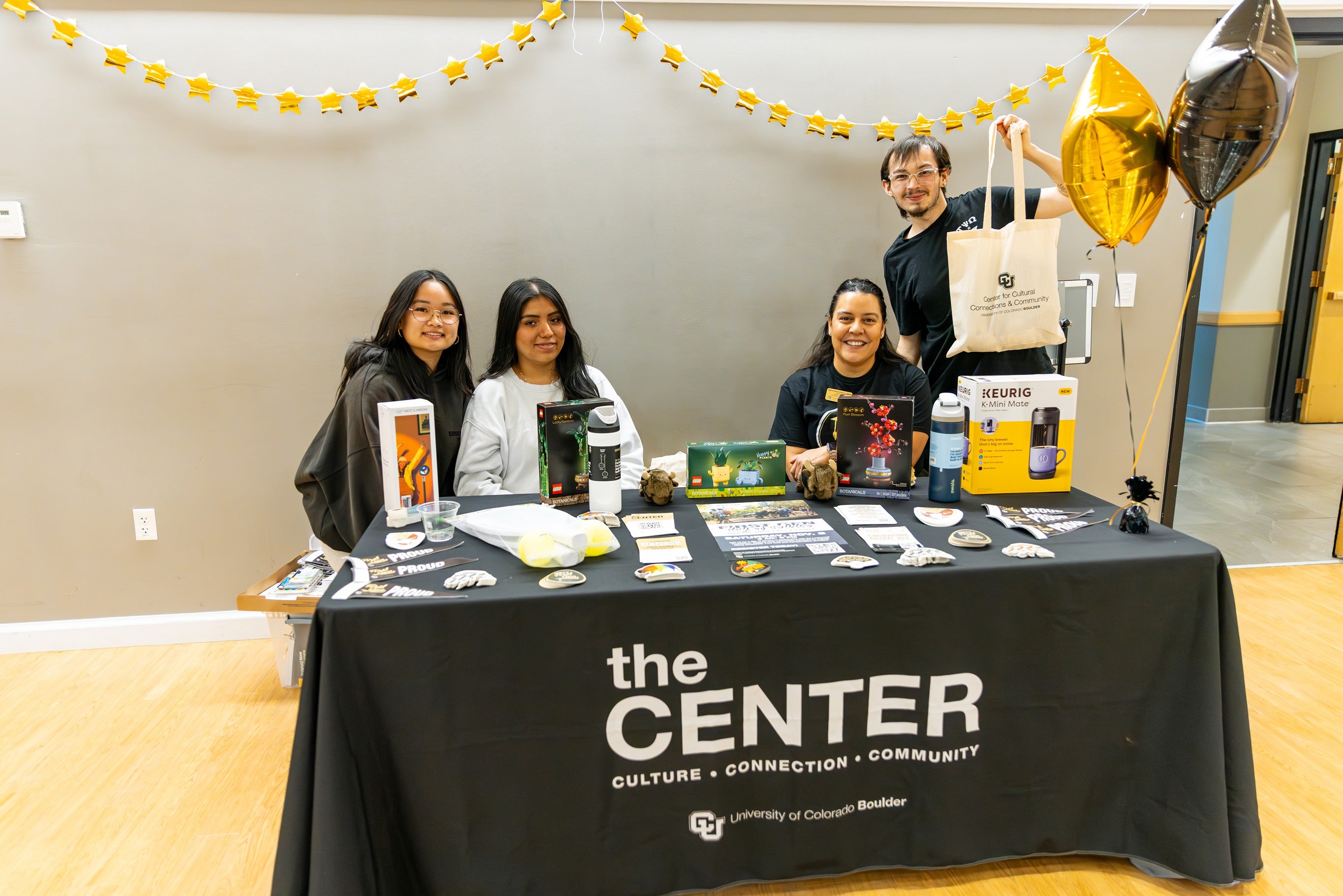 People pose behind The Center booth at First-Gen celebration day