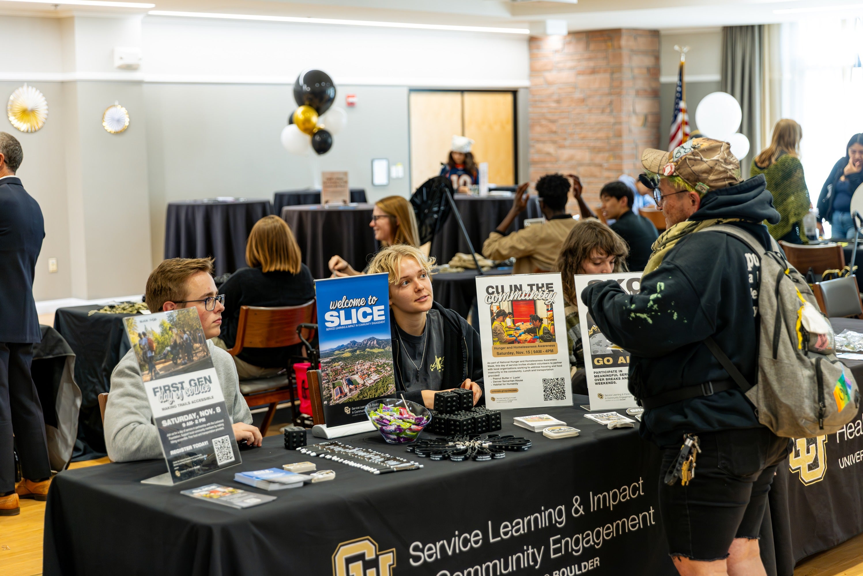students interacting with people behind booth at First-Gen celebration day