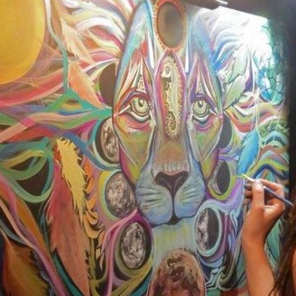 Artist Laura McGowan painting a lion