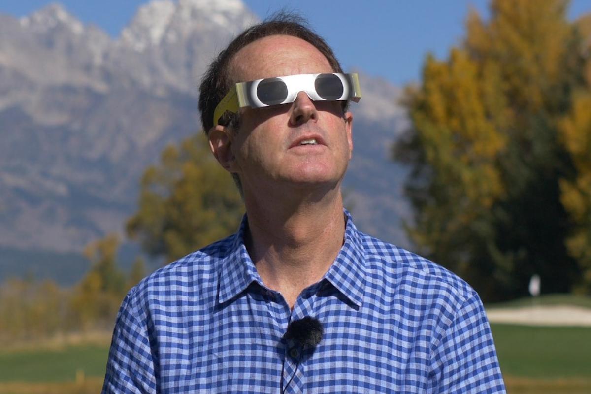 Doug Duncan wearing eclipse glasses and looking up
