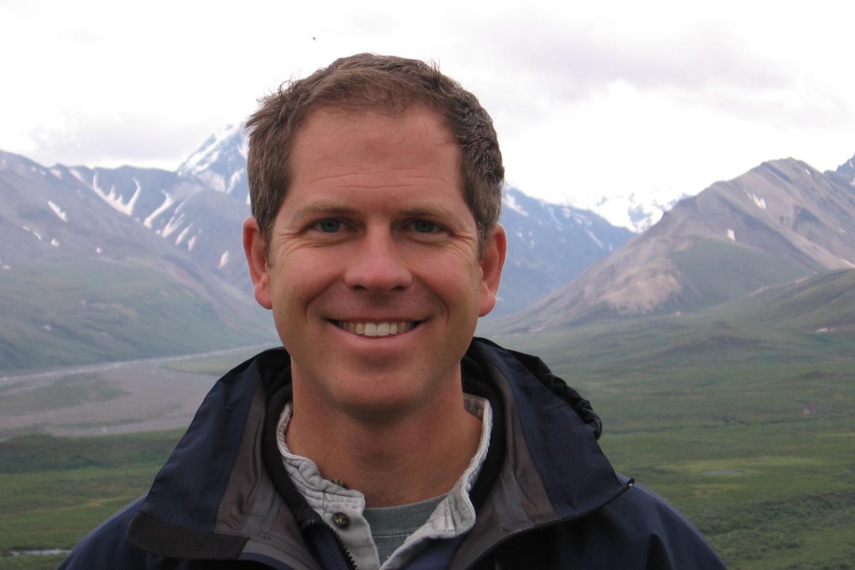 John Keller looking at camera with mountains in background