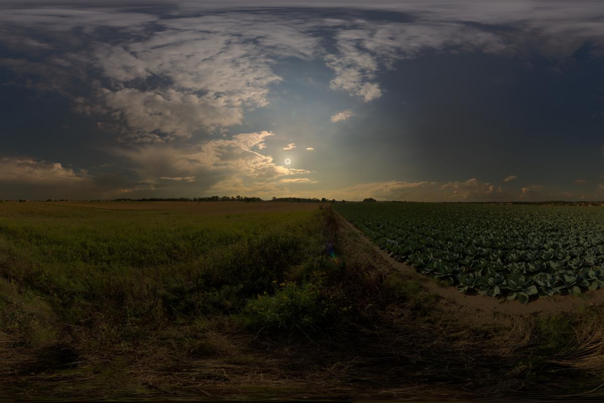 Annual eclipse just visible above the horizon with landscape and clouds
