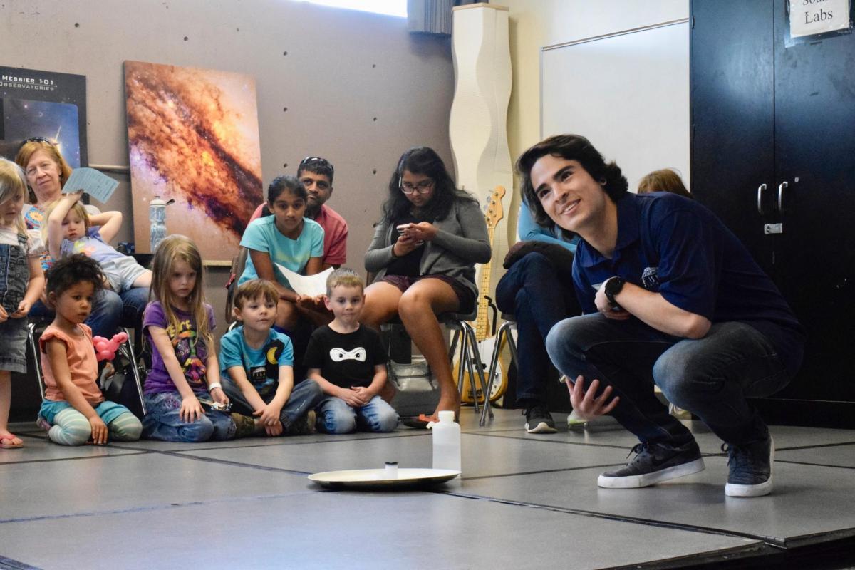 Teacher doing a demonstration in classroom with kids and families