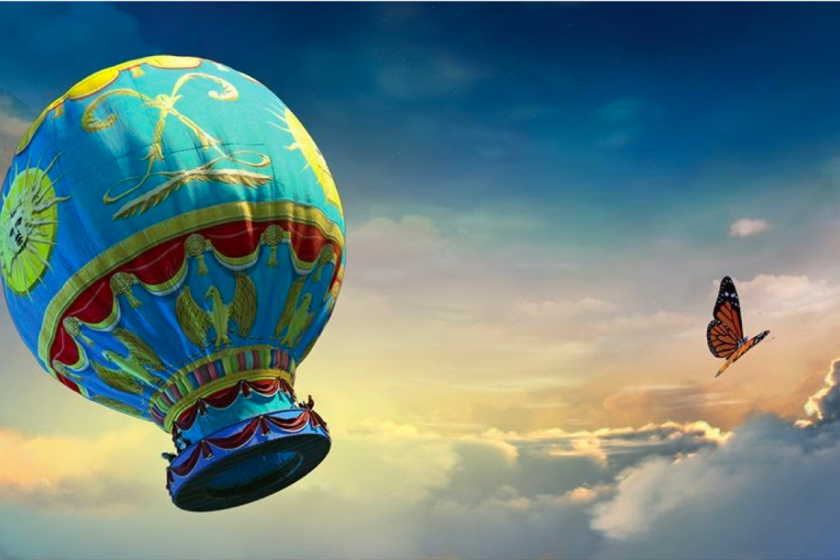 Still image from film with a hot air ballon, airplane, butterflies and dragonflies against a cloud filled sky