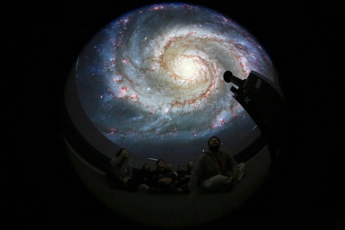 Inside Fiske Minidome image of M51 galaxy on dome and students looking up
