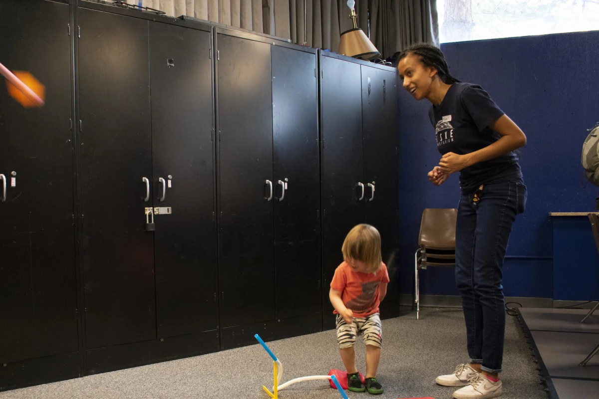 Teacher showing young child how to launch a stomp rocket