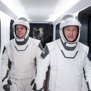 NASA astronauts Bob Behnken, left, and Doug Hurley, wearing SpaceX spacesuits, walk through the Crew Access Arm connecting the launch tower to the SpaceX Crew Dragon spacecraft during a dress rehearsal at NASA’s Kennedy Space Center in Florida on Jan. 17, 2020. Credits: SpaceX