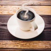 Graphic of a cup and a saucer on a wooden slat table with a galaxy image in the liquid area with steam