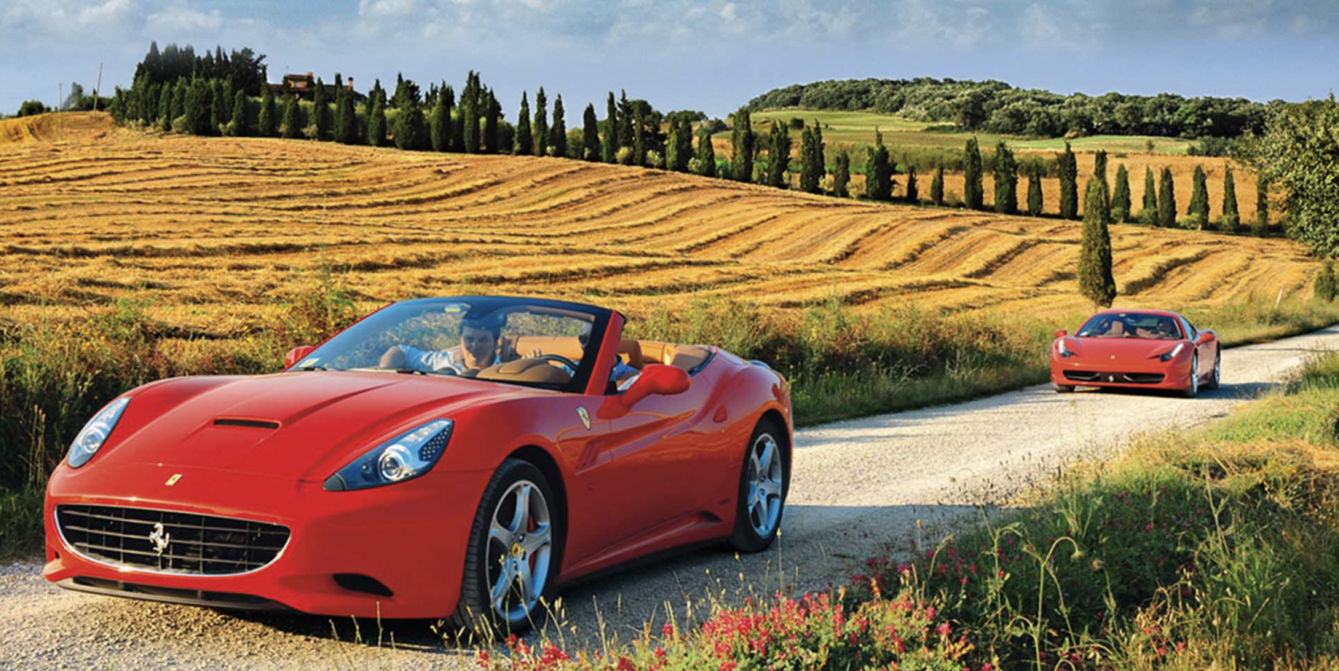 Expensive new red convertable cars driving down an a road in the country side in Italy.