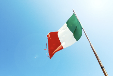 Image of an Italian flag on a blue sky background