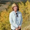 An image of Cosetta Seno in from of a field of aspen trees in the fall