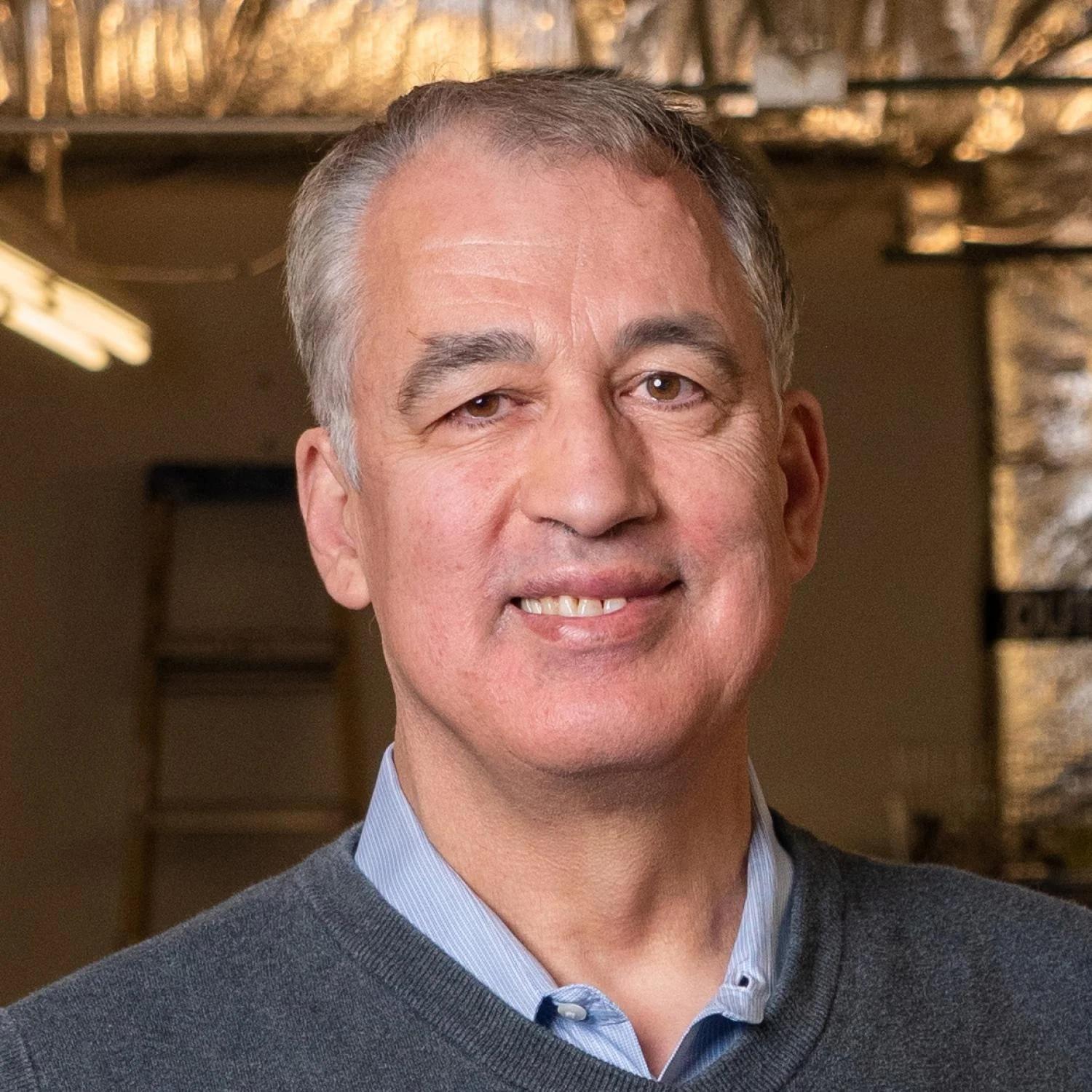 Moncef Krarti in a sweater with a button-down shirt underneath