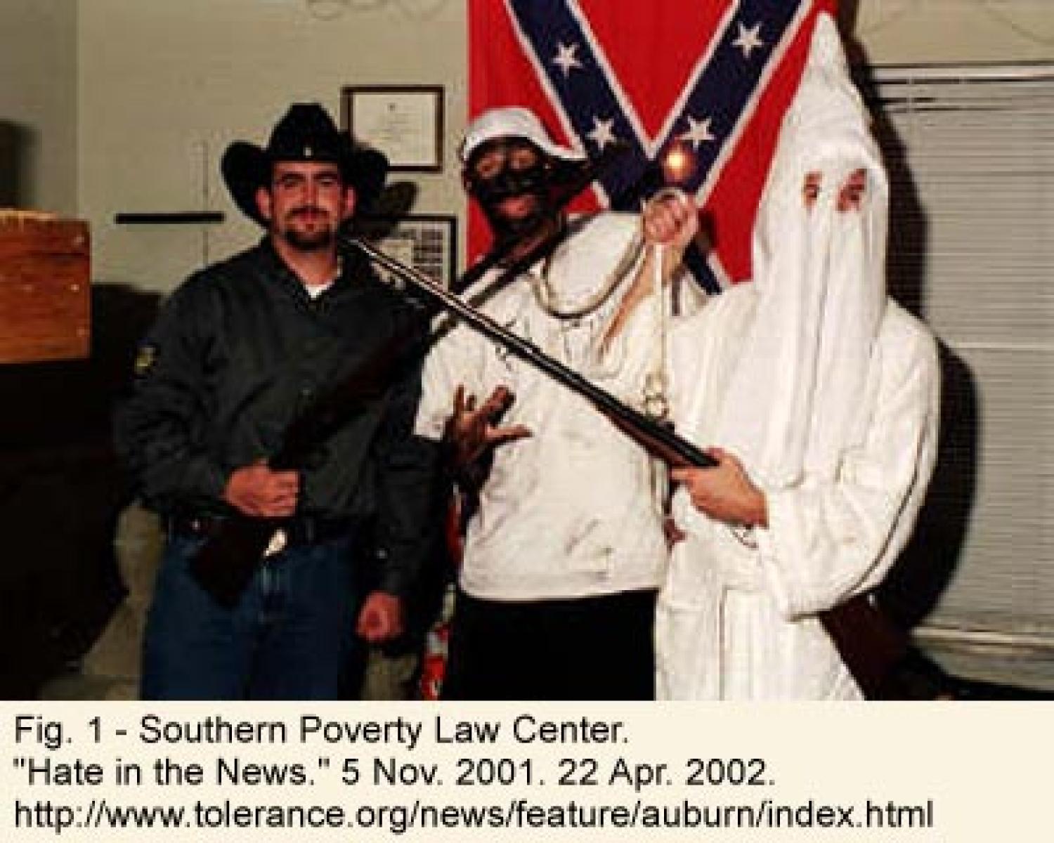 Figure 1: Southern Poverty Law Center - "Hate in the News." Three white men stand in front of a confederate flag. One is dressed as a KKK member and is holding a noose around the neck of one dressed in blackface. The third holds a rifle in front of the one wearing blackface.