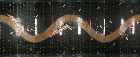  Image from above of the physical model after an experiment was conducted. Orange, white, and green pieces are scattered around the model. Flow is from left to right. 