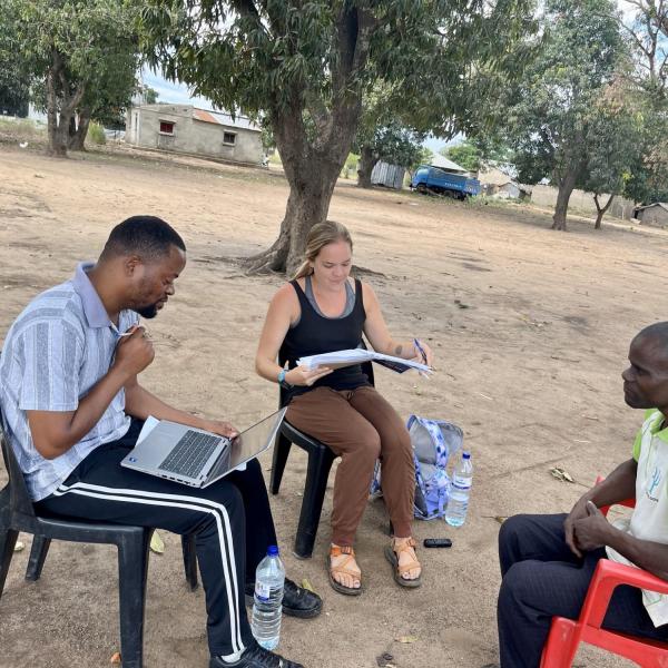 Eduardo Mondlane University master’s student and research assistant Aldimiro Carlos translates from the local language of Sena to Portuguese while Herwehe takes notes during an interview with a farmer in Metuchira, Sofala.